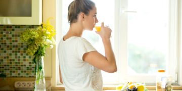 portrait-attractive-woman-drinking-juice-kitchen